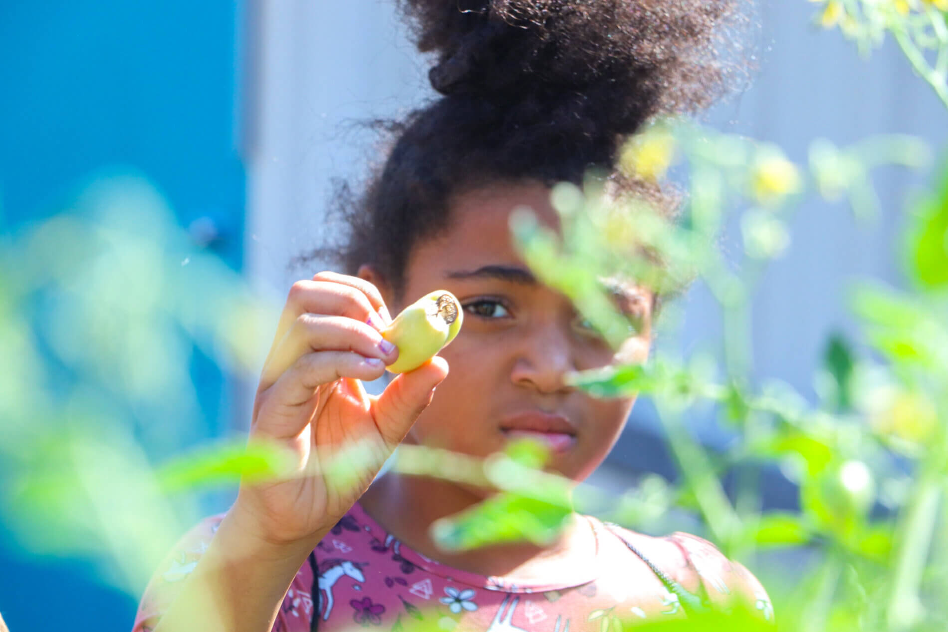A teenage girl shows off the products in her school's community garden.